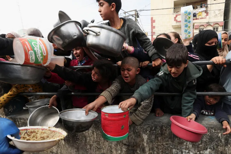 A child receiving bread from an aid worker